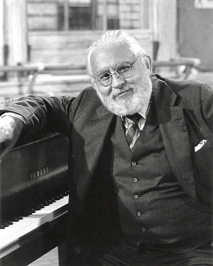 UC alum Al Hague stands near his piano.