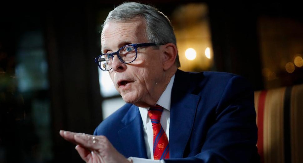 A man in a suit points a finger