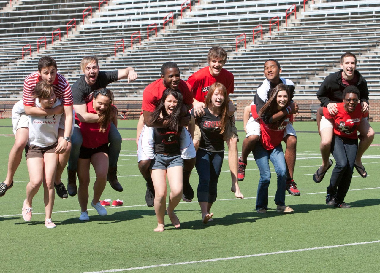 Students carries others on piggy-back across the football field