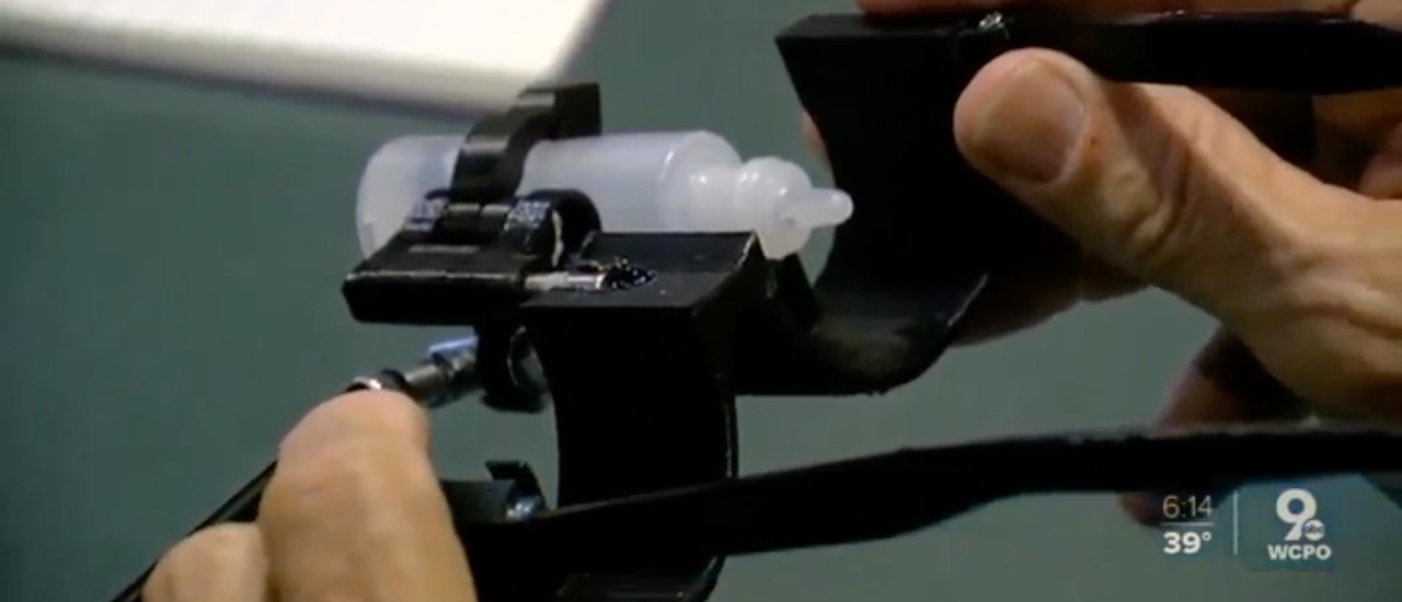 Hands hold a custom eyedropper designed by UC students.