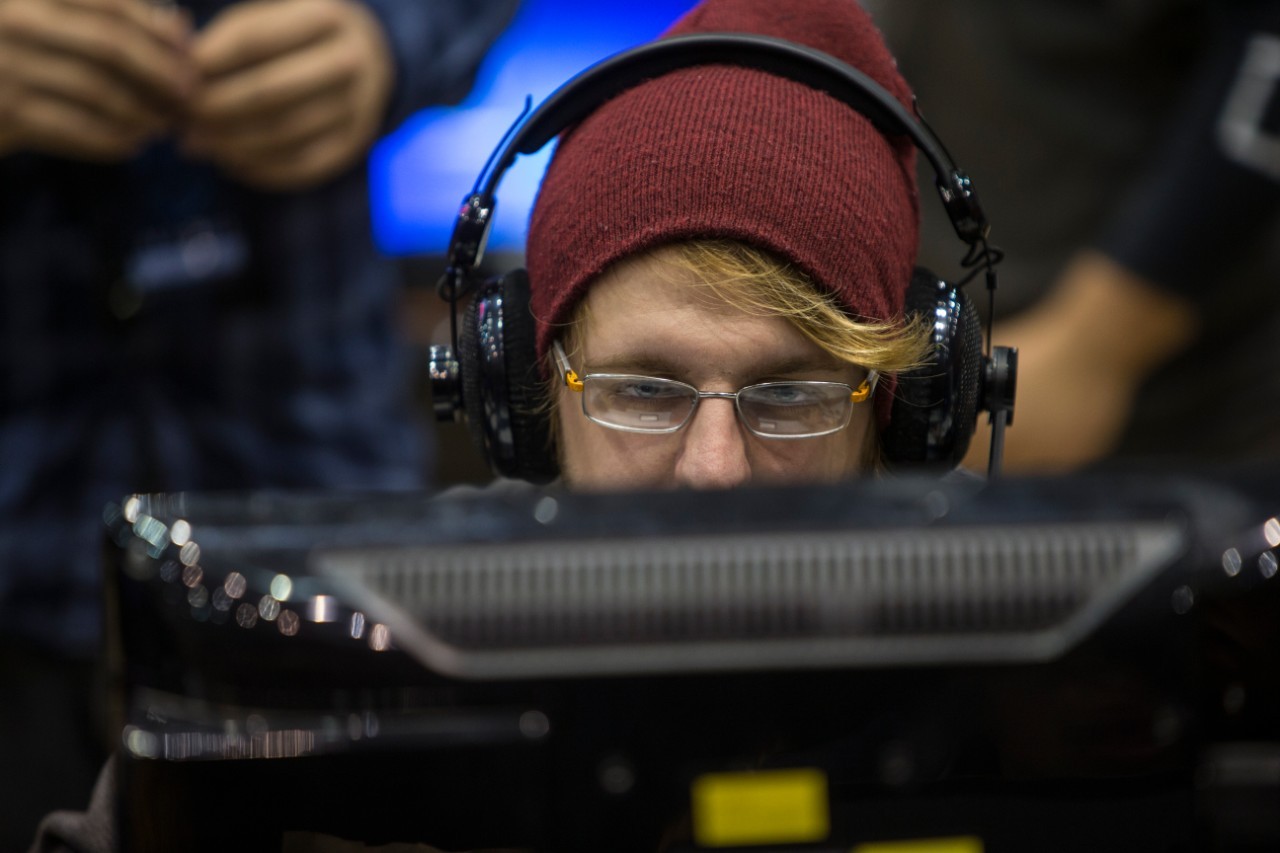 A student in headphones sits at a computer.