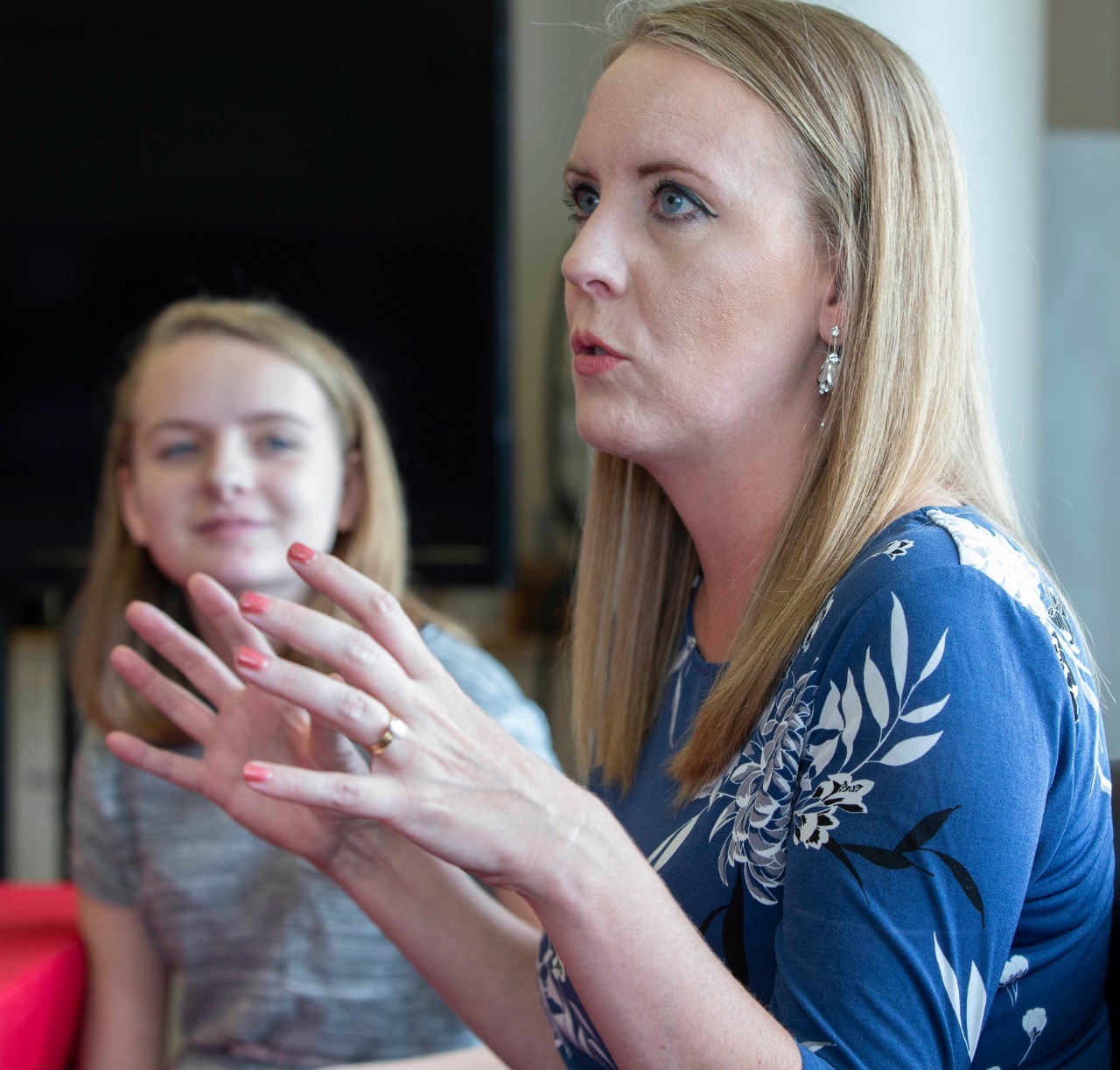 Heather Powell talks while her daughter listens next to her.