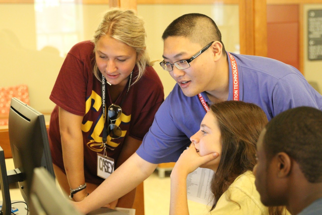 Students crowd around a computer screen.