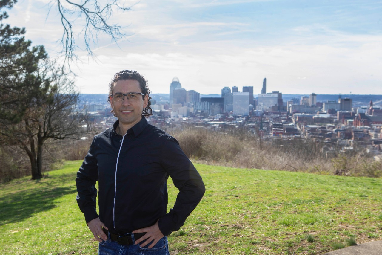Diego Cuadros, PhD assistant professor of geography shown here at Bellievue Hill Park with the City of Cincinnati in the background. UC/Joseph Fuqua II 