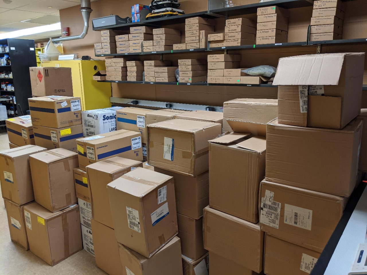 Cardboard boxes are stacked in a storeroom.