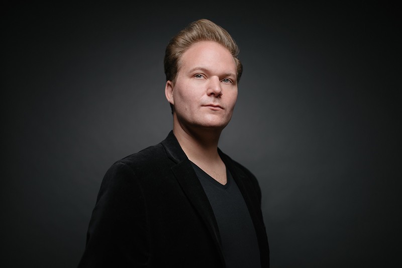 A conductor poses for a headshot