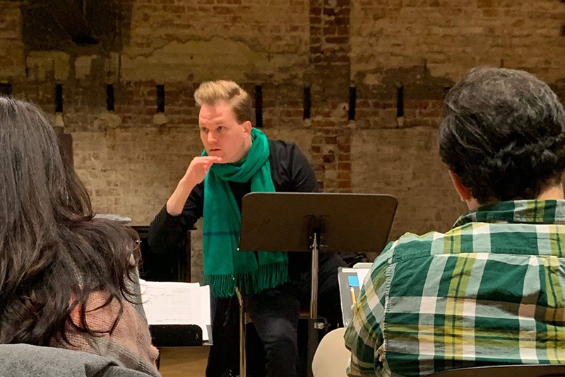 A conductor leads a workshop of an opera