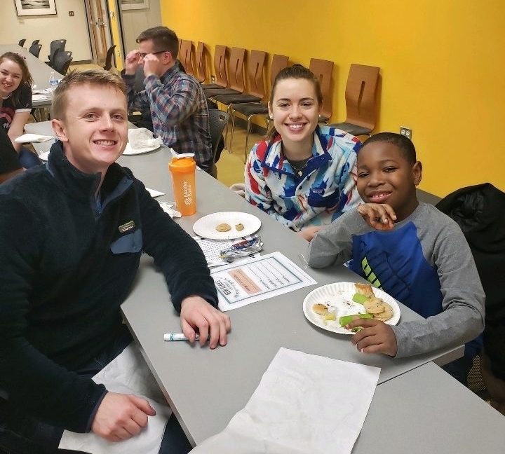 Medical students Nathan Lawera and Emilie Buisson are shown with second-grader  Romendo Sims.