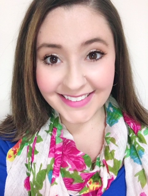A woman smiling wearing a colorful scarf