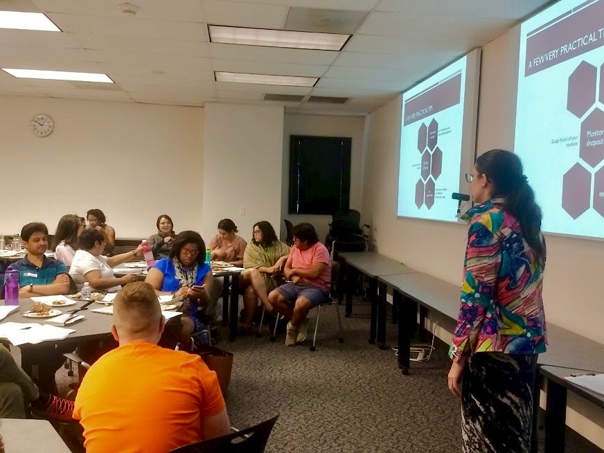 UC's Crystal Whetstone stands at a whiteboard before a class of students.