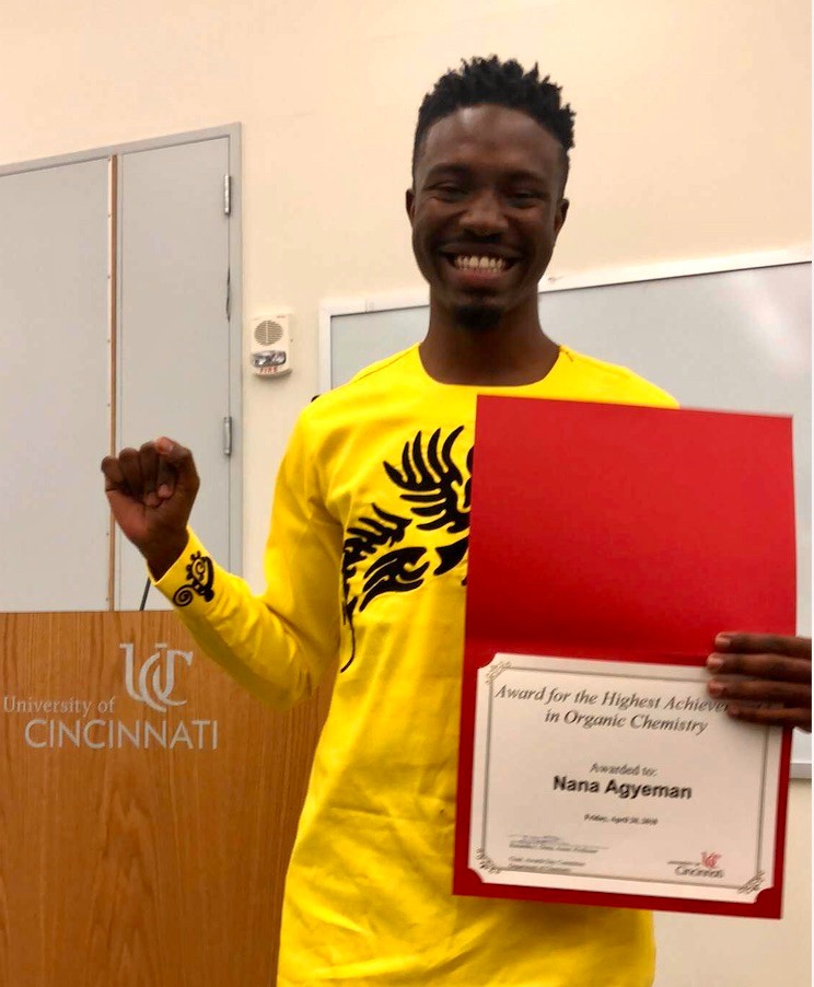 UC's Nana Agyeman stands holding his organic chemistry award.