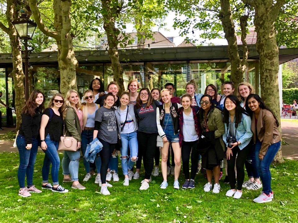 Several UC students stand outside a government building in Amsterdam while on a study abroad trip.