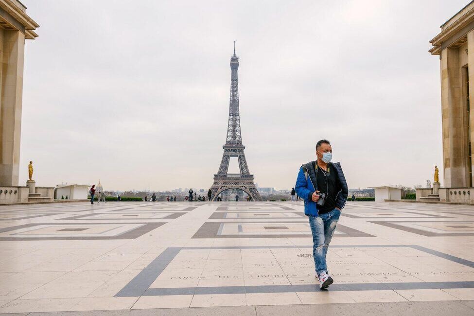  A man walks through a deserted Trocadero Square in Paris wearing a medical mask