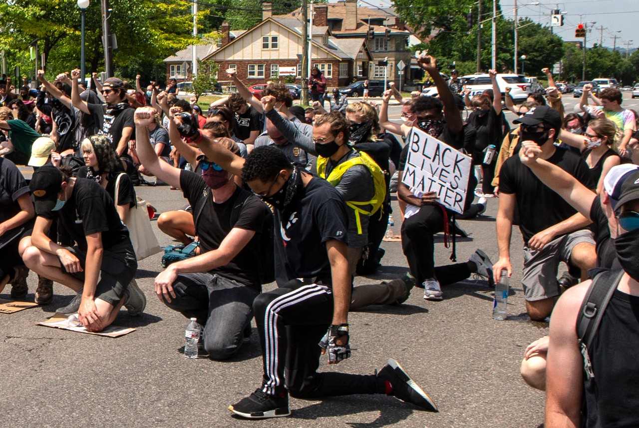 University of Cincinnati police Assistant Chief Dudley Smith, middle and Captain Rodney Carter middle far back kneeled with protesters on Clifton Avenue at MLK.  University of Cincinnati police Assistant Chief Dudley Smith and Captain Rodney Carter walked with the protesters along Clifton and King, MLK to Jefferson, south on Jefferson, west on Calhoun and Clifton Avenue. About 800 protesters marched for George Floyd, Breonna Taylor and Ahmaud Arbery Wednesday June 3, 2020 as part of a Black Lives Matter Cincinnati action. UC/ Joseph Fuqua II