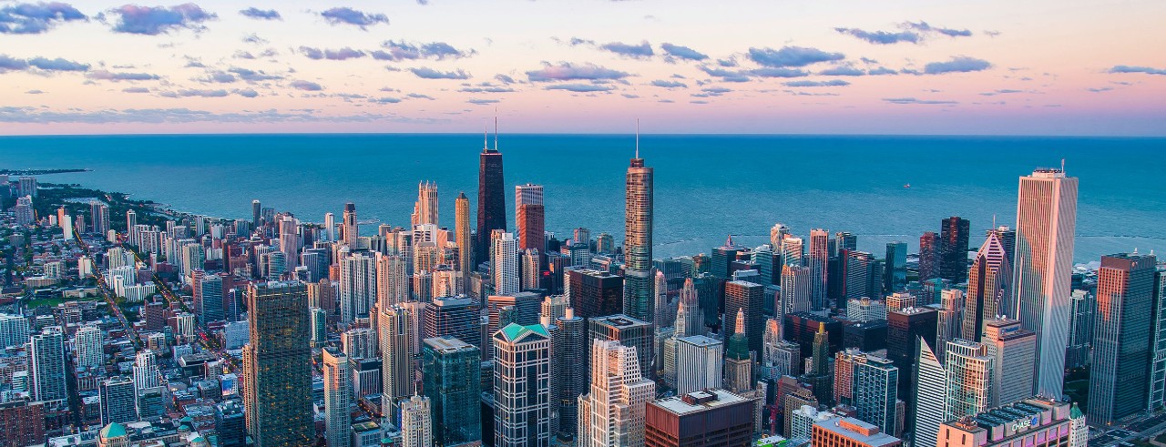 Metropolitan city skyline with lake and sky in background.