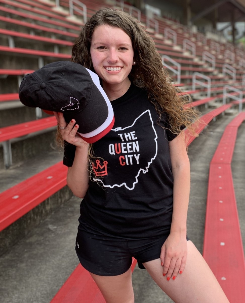 Grace Hertlein poses in UC gear on the bleachers of Nippert Stadium.