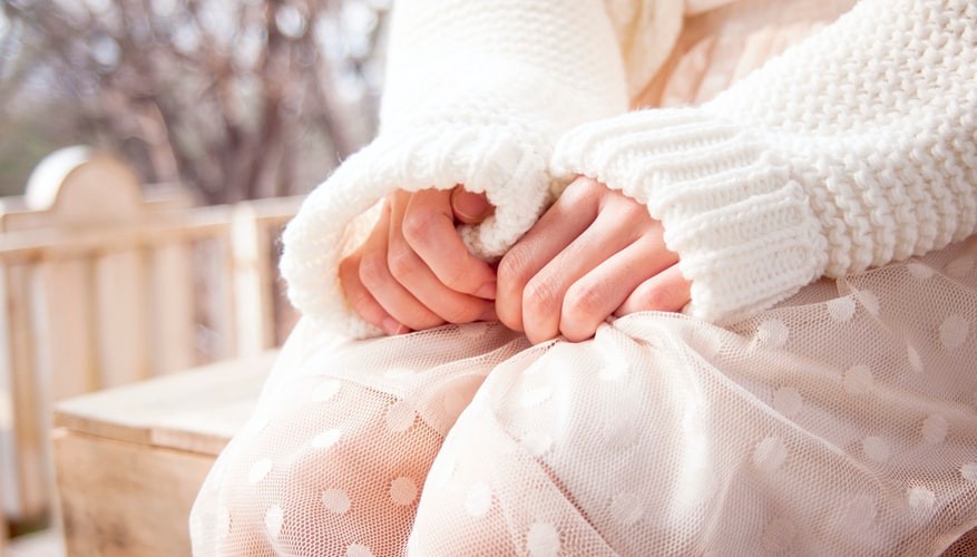 image of a women's hand clutching her pants in panic