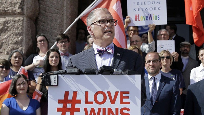 Jim Obergefell stands in front of the UC sign and fountain on campus