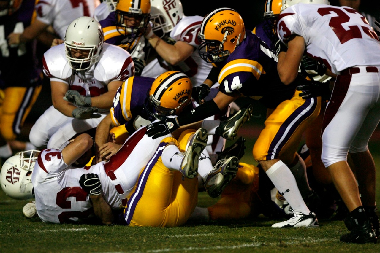 image of football teams tackling players