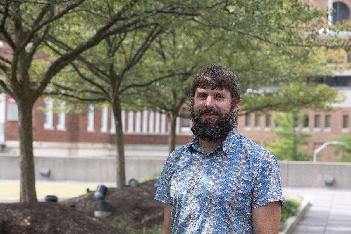 Michael Booth stands in a courtyard at UC.