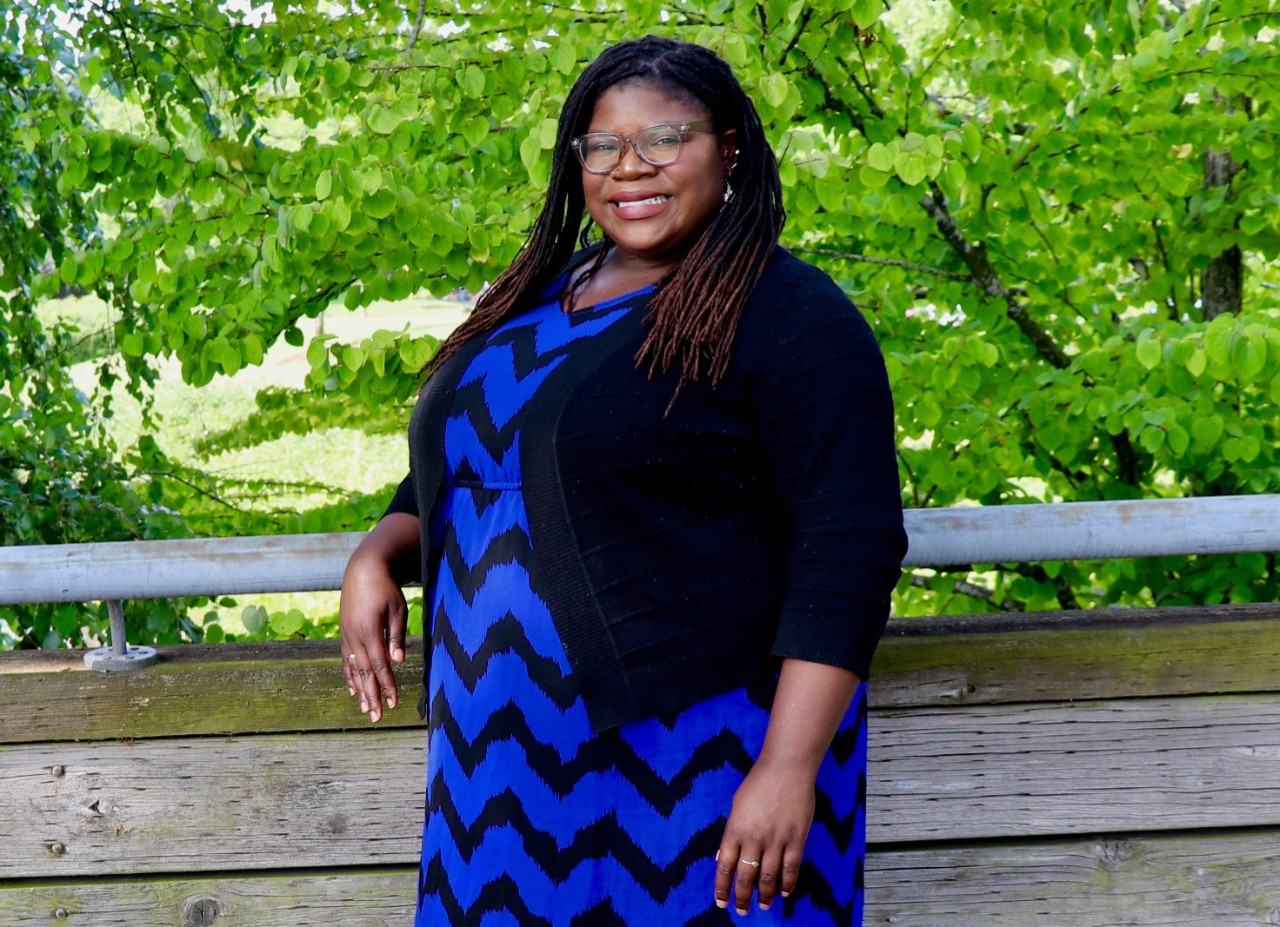 Shaonta' Allen poses in front of green trees. 