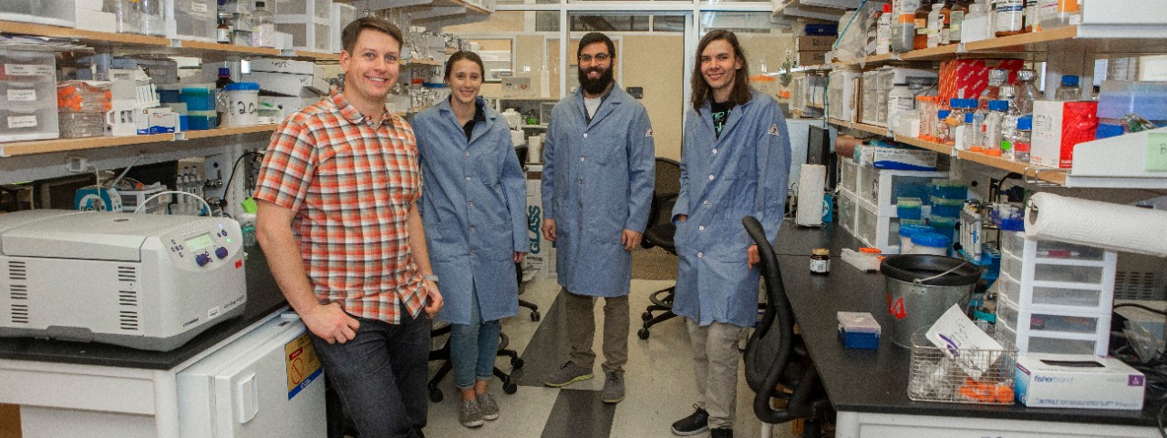 UC biologist Joshua Benoit with his students in his biology lab.