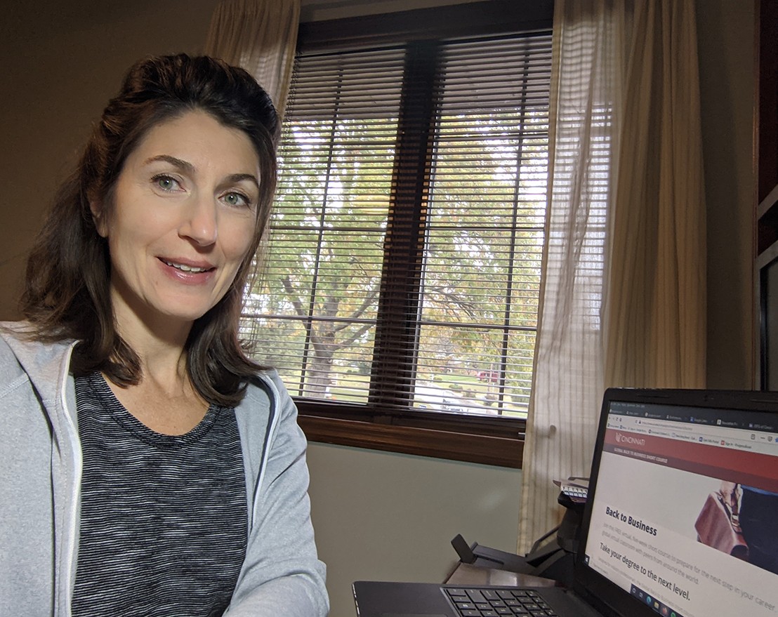 Schroer sits in a home office with a laptop showing the global back to business site 