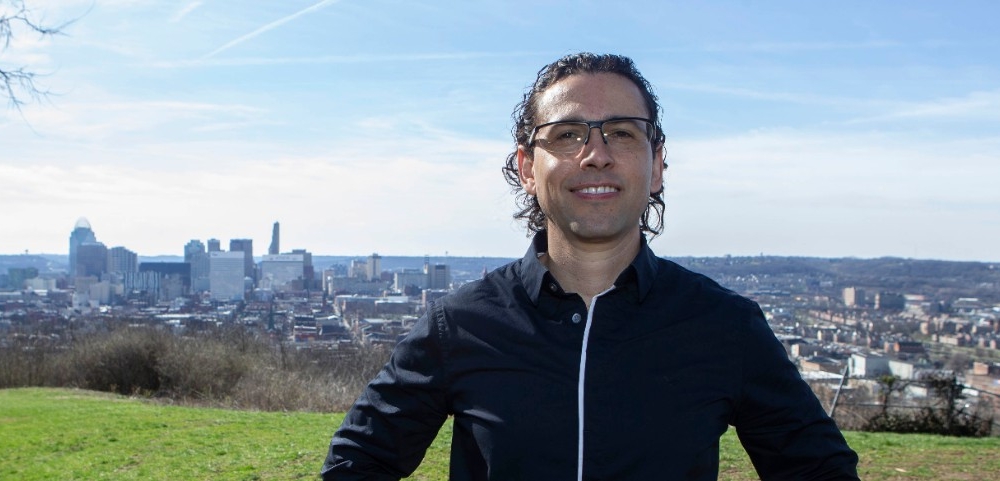 Diego Cuadros, PhD assistant professor of geography shown here at Bellievue Hill Park with the City of Cincinnati in the background. UC/Joseph Fuqua II 