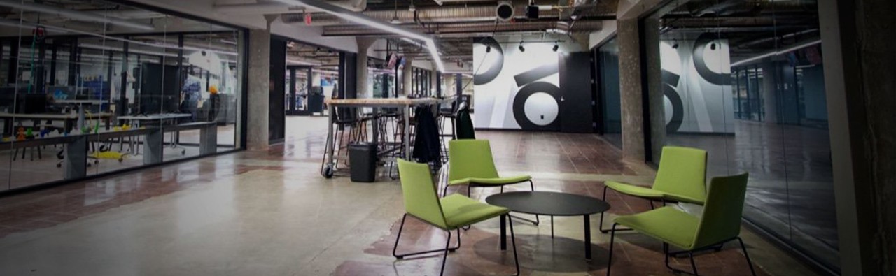 The makerspace at the 1819 Innovation Hub. A small round table with three chairs arranged around it appears in the foreground. 