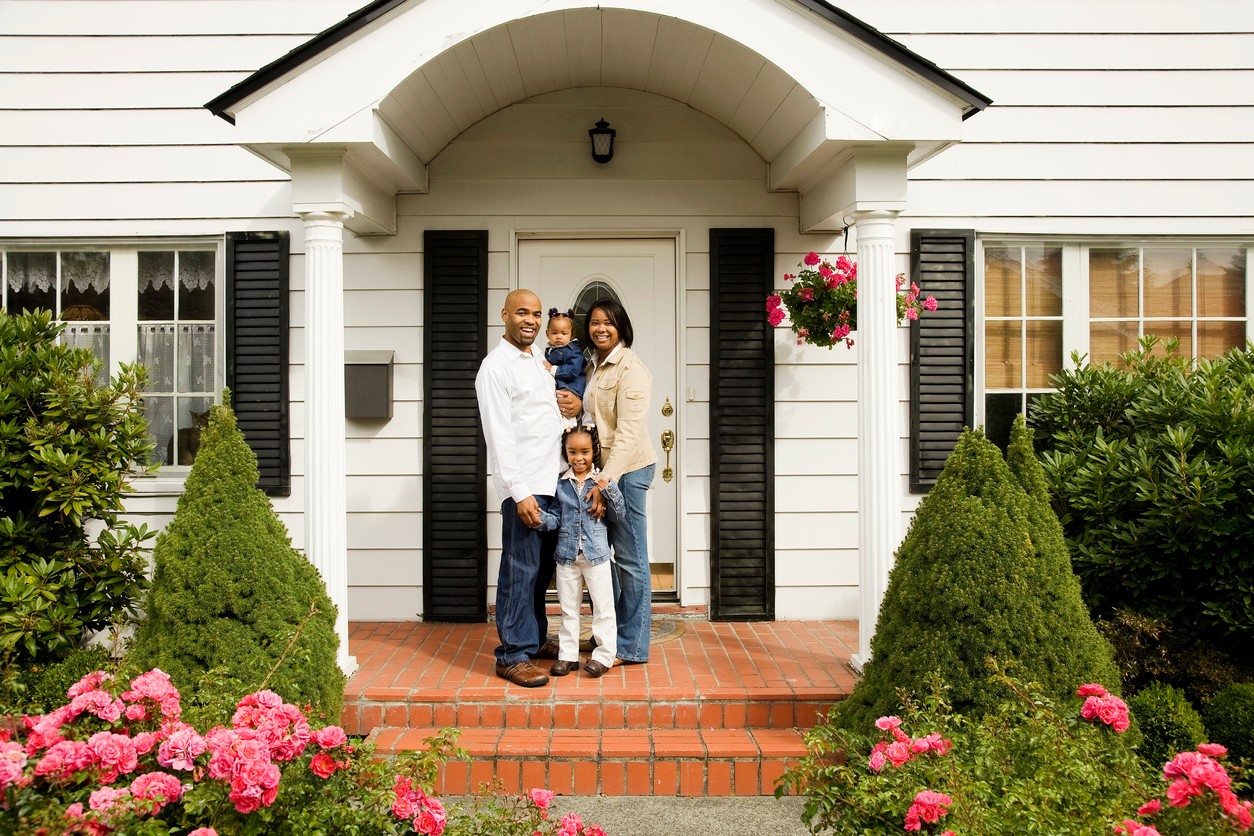 African American family in front of new home