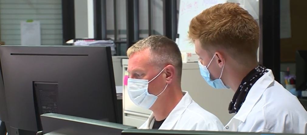 A&S Neuropsychology major Alex Powell, right, at work in a Gravity Diagnostics lab. 