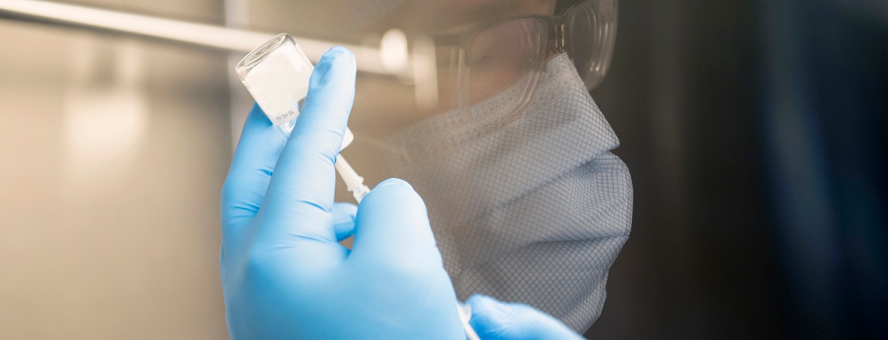 a pharmacist prepares a dose of COVID-19 vaccine