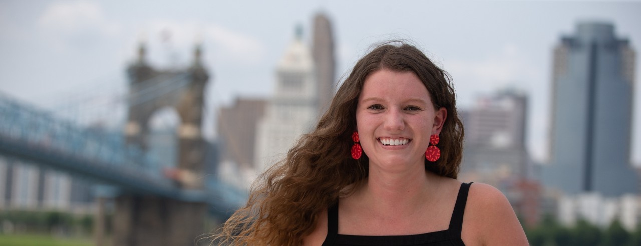 Grace Hertlein smiles in front of Cincinnati riverfront
