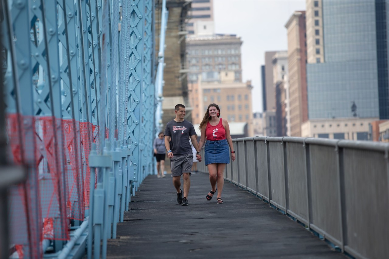 Grace Hertlein and fiance Tim Hawk walk across a bridge in Cincinnati