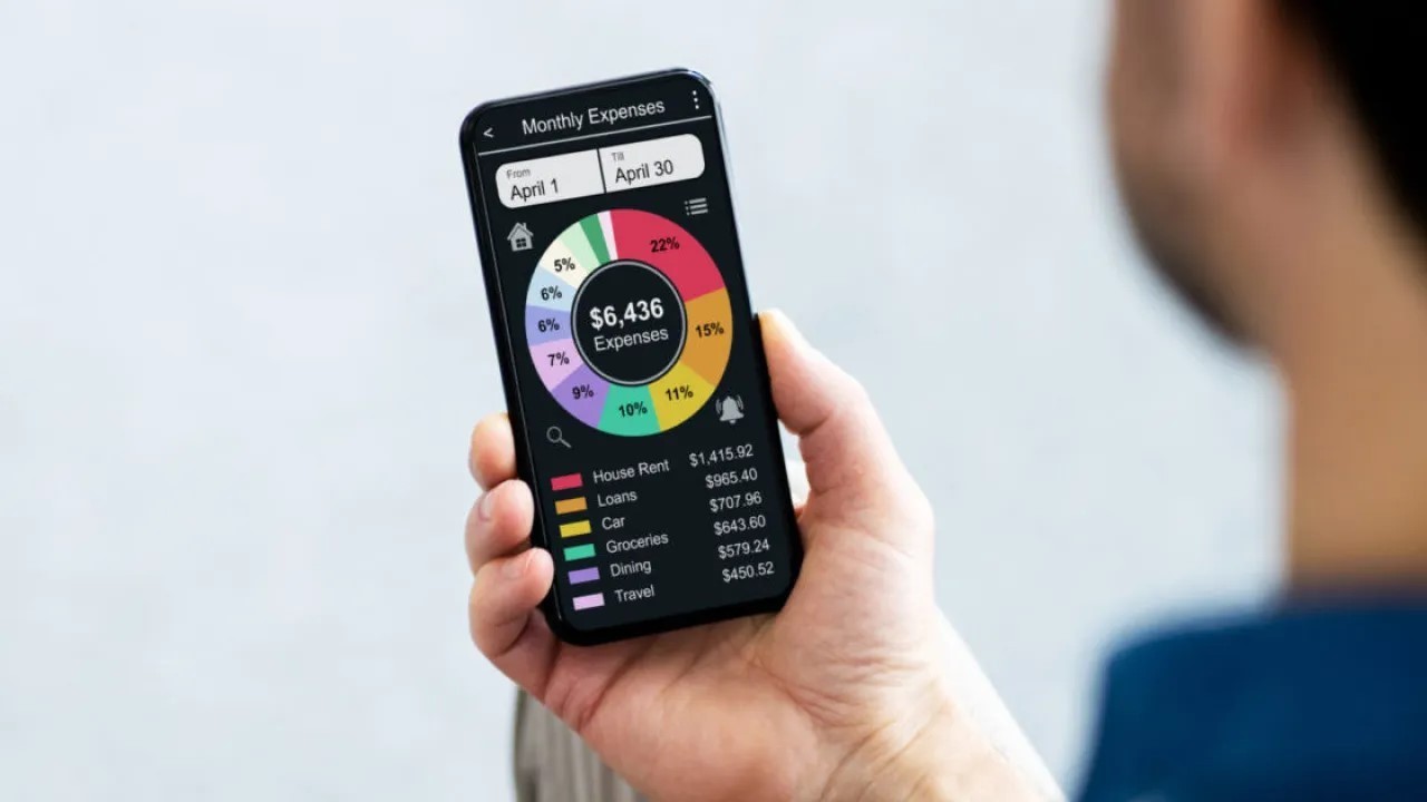 man holding phone with budgeting tool on screen