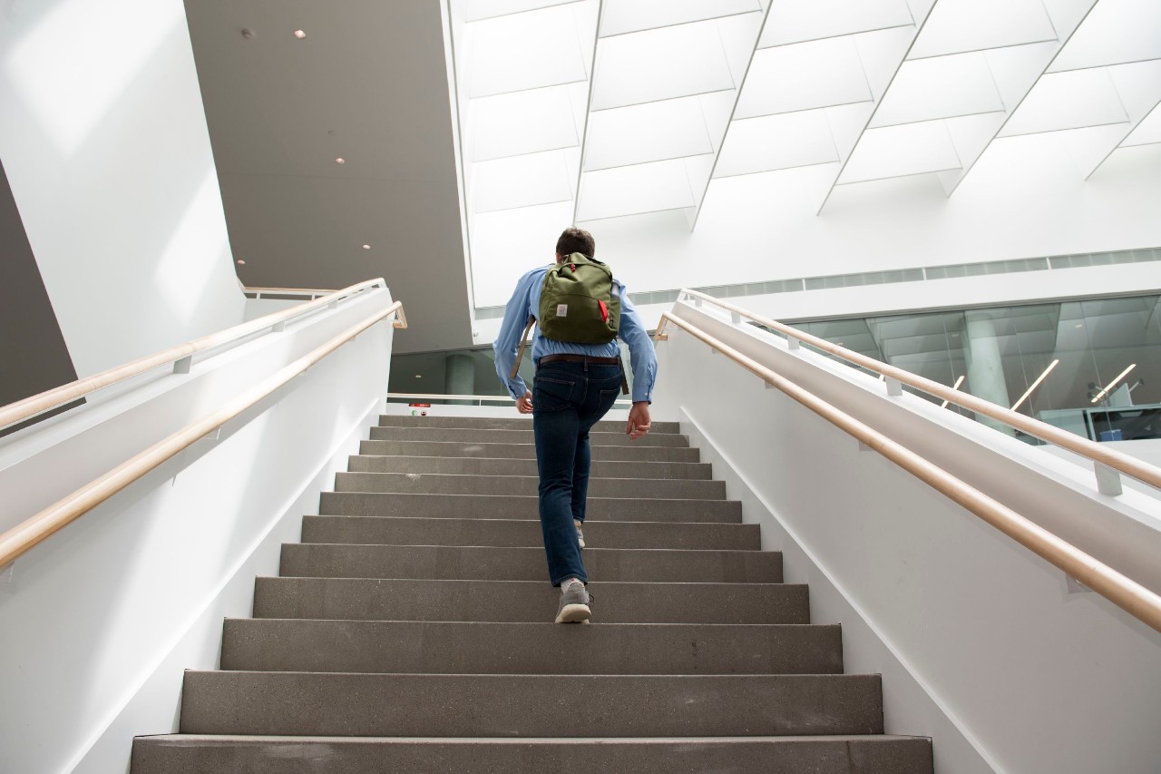 Man walking up stairs photographed from behind