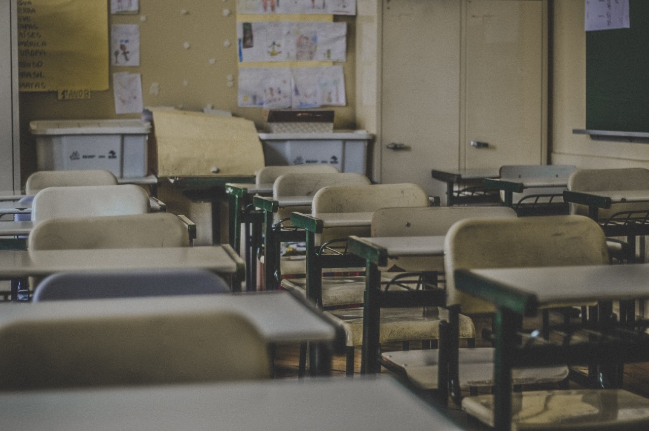 Rows of desks sit empty in a classroom