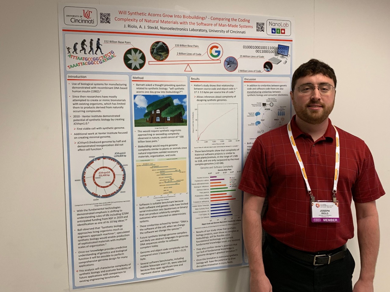 Joseph Riolo stands next to a poster of a paper he co-authored.