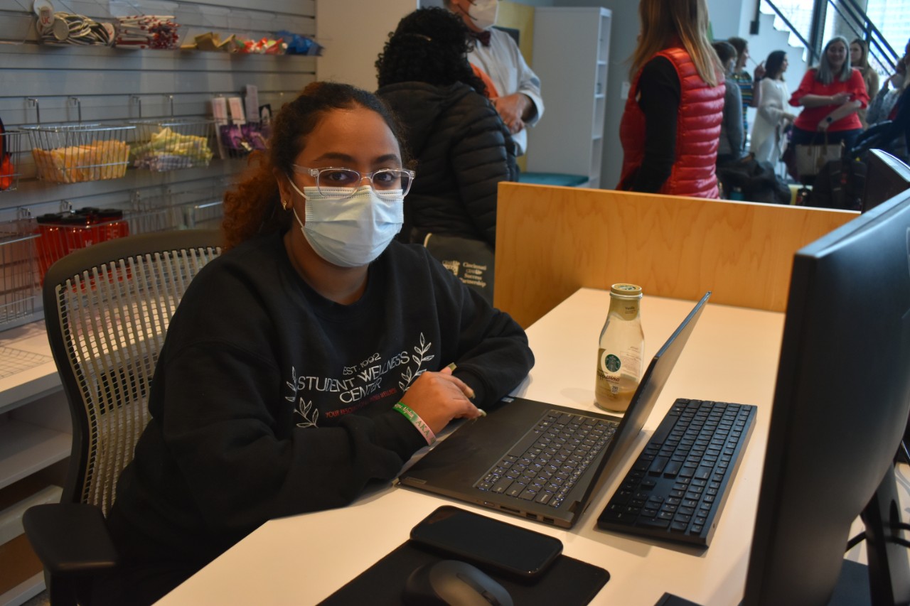 A student sits at the new Student Wellness Center welcome desk computer.