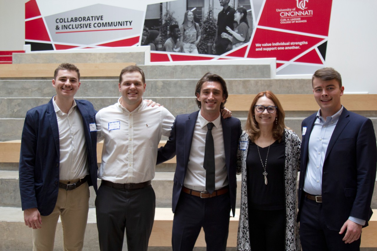 Four men and a woman pose for a photo.