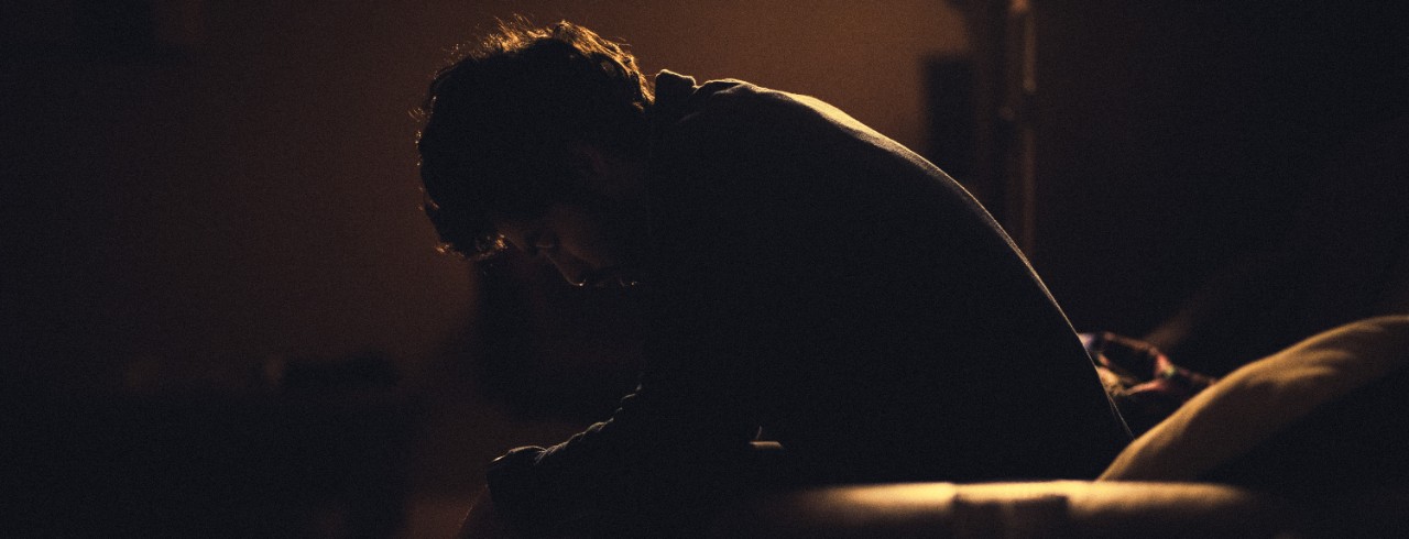 A man sits with his head down