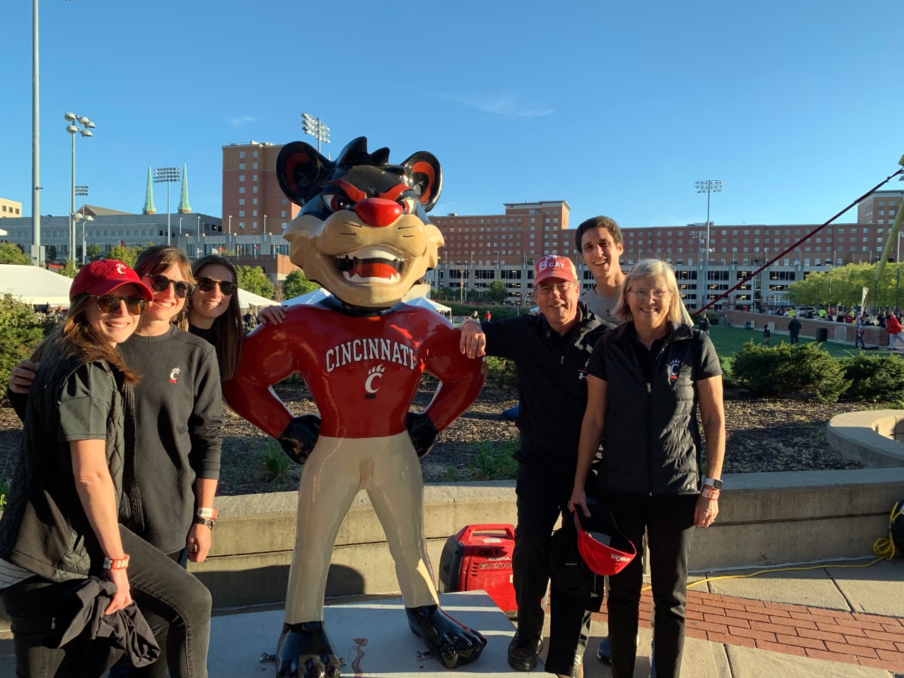 Adults with bearcat statue on UC's campus