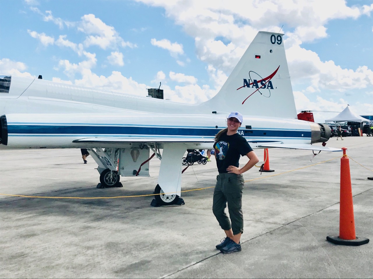 Anna Lanzillotta poses on the tarmac in front of an airplane badged with the NASA logo