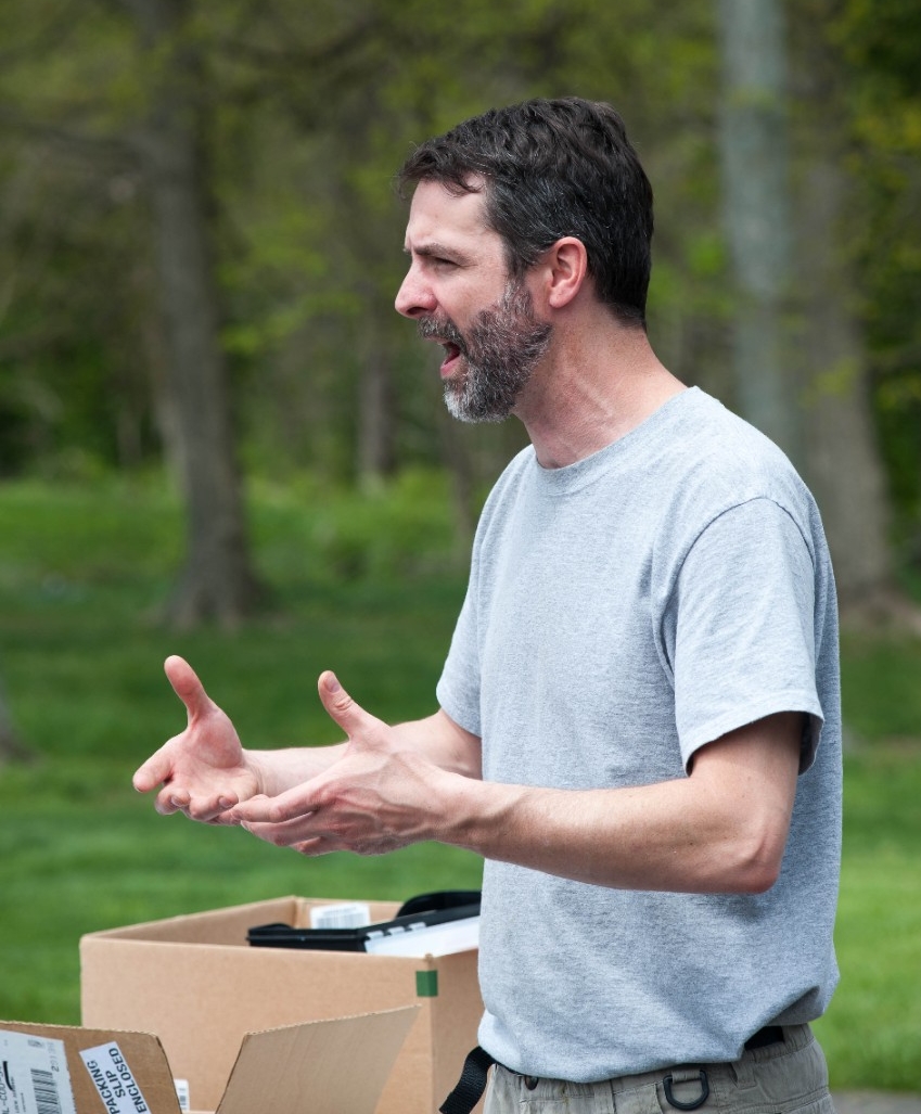 Adam Lehmann gestures while talking to volunteers.