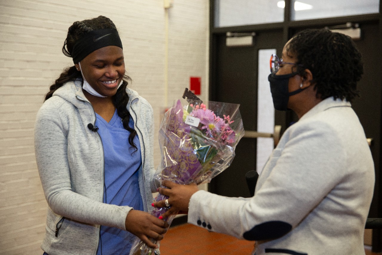 Hughes High School Prinicipal Dr. Jennifer Williams congratulations Benya Coleman with flowers.