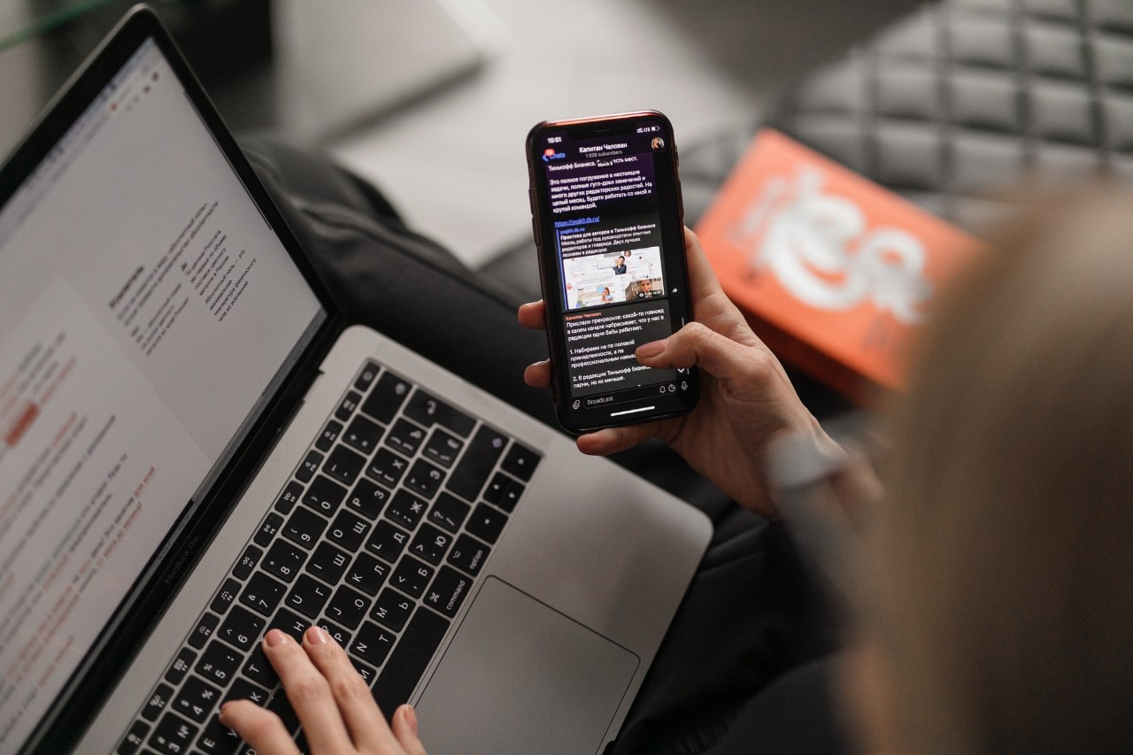 person using computer and cellphone at the same time to search the internet