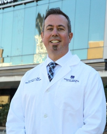 Neil MacKinnon stands in a labcoat outside the Medical College of Georgia.