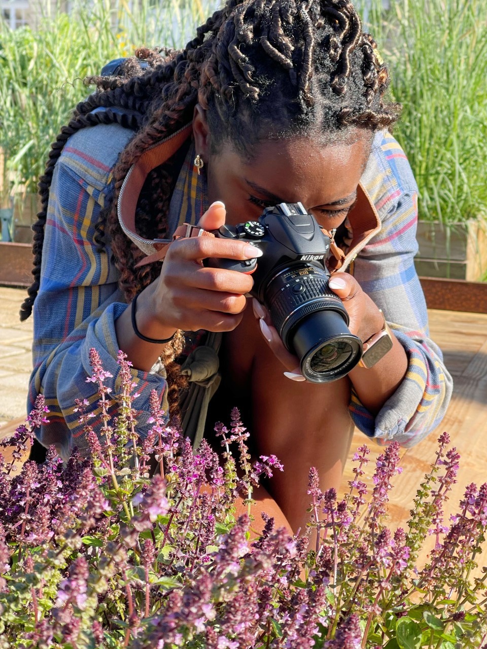 a woman taking close up photos of bees on flowers