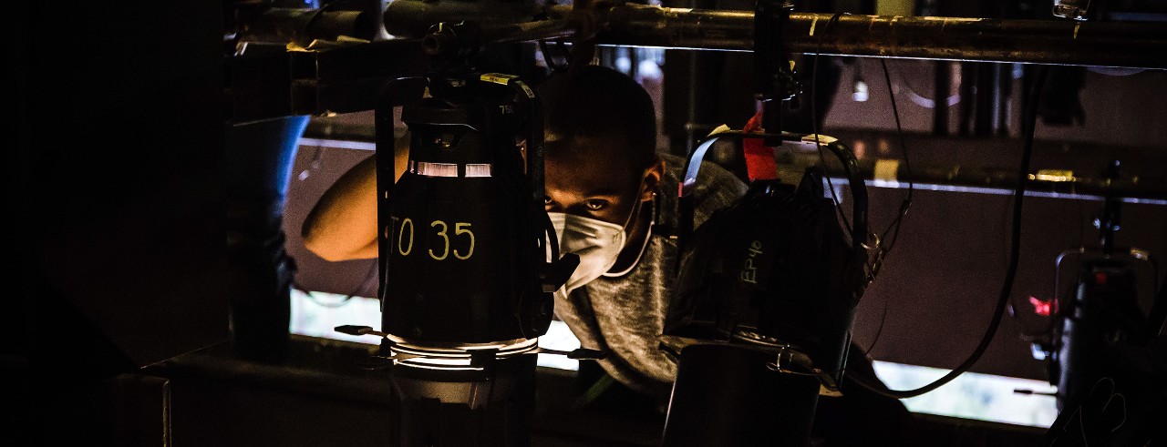 Dionte Mercado working on lighting behind the scenes.