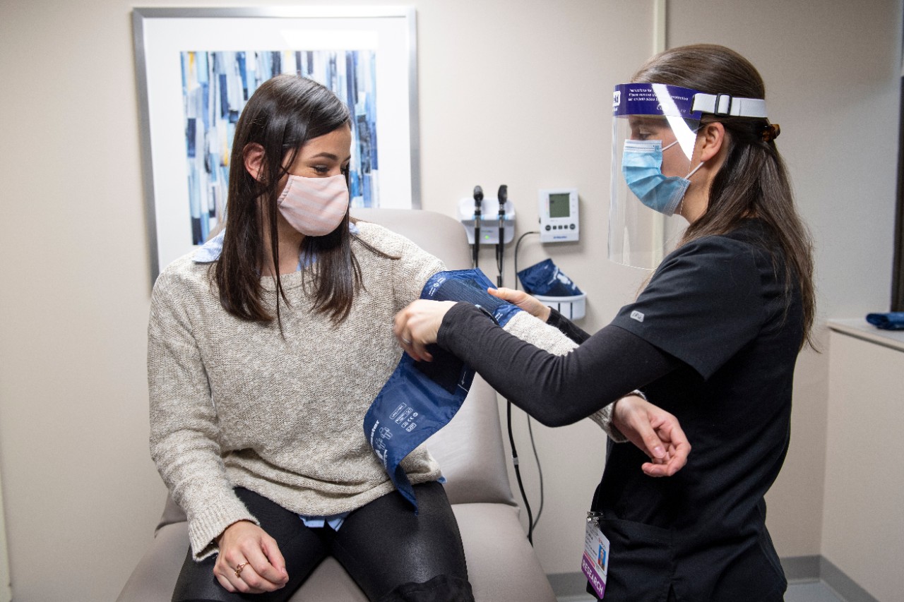 Shaina Horner, Division of Infectious Diseases, taking Cristina Morgan (daughter) blood pressure.  Shaina was instrumental in recruiting for the Moderna COVID-19 vaccine trial in Cincinnati.